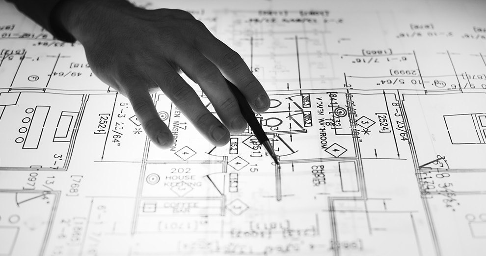 Main pointant sur des plans